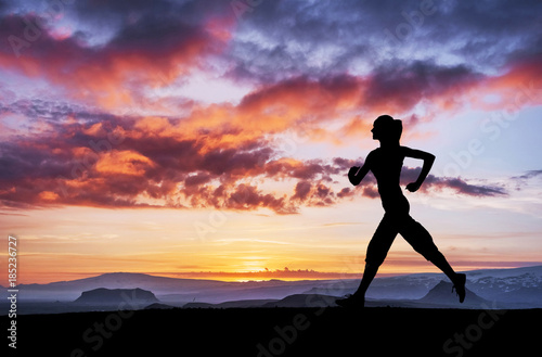 A sports girl at dawn is engaged in yoga. Fitness classes at sunset