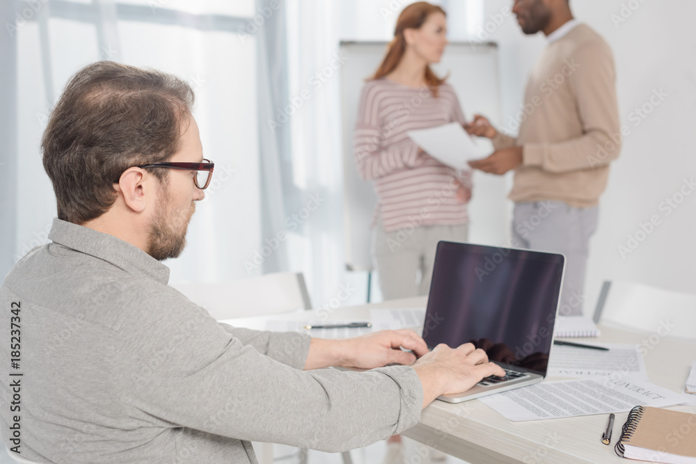 middle aged man in in eyeglasses using laptop with blank screen in office middle aged man in in eyeglasses using laptop with blank screen in office