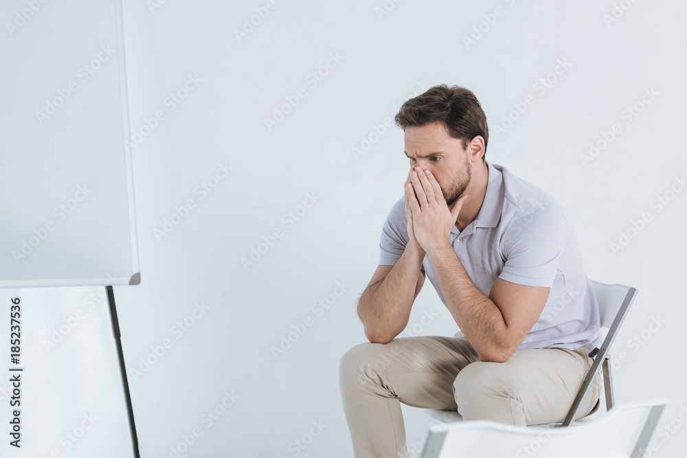 depressed man sitting and looking away indoors depressed man sitting and looking away indoors