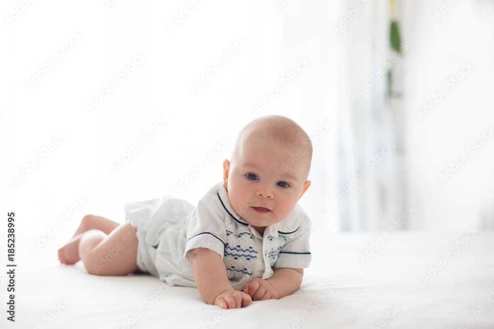 Cute little four month old baby boy, playing at home in bed Cute little four month old baby boy, playing at home in bed