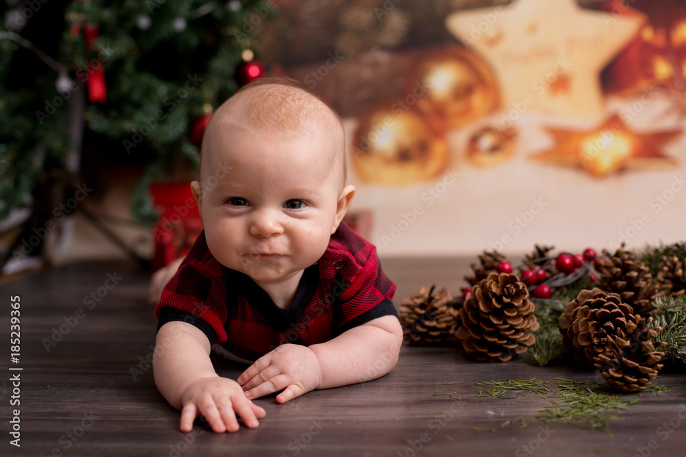 Little baby boy with christmas clothes, lying on the floor Little baby boy with christmas clothes, lying on the floor