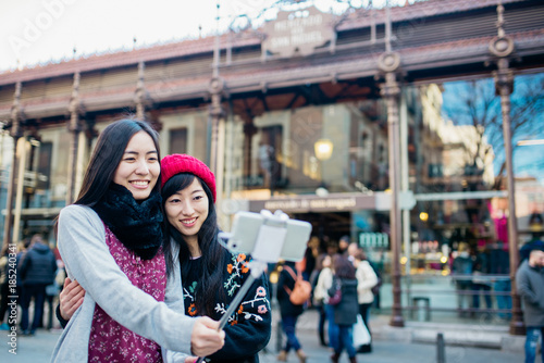 Asian women taking selfie on street