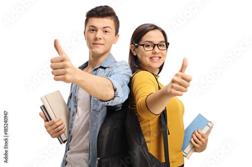 Konstfotografi Teenage students with backpacks and books making thumb up gestures