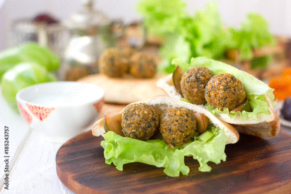 Nice vegetarian falafel in pita bread on wooden board. Nice vegetarian falafel in pita bread on wooden board.