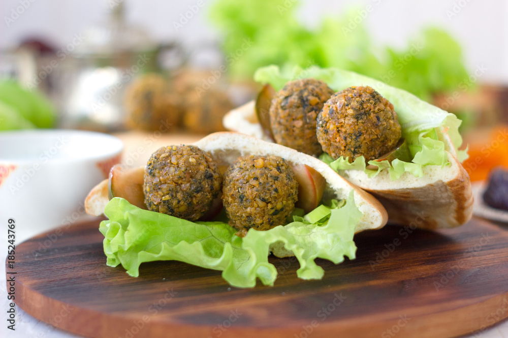 Nice vegetarian falafel in pita bread on wooden board.