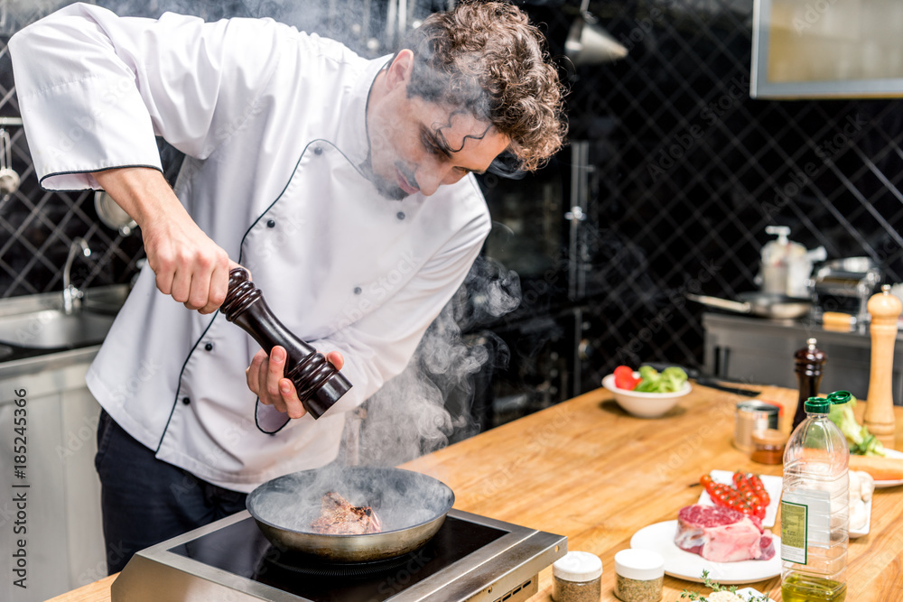chef seasoning frying meat with pepper chef seasoning frying meat with pepper