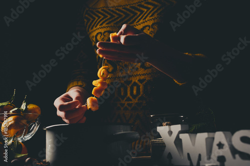 Female hands cooking orange jam for Christmas gifts