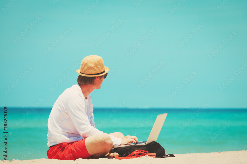 remote work -man with laptop on beach