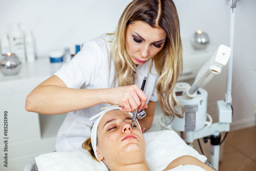 Cosmetologist is doing procedure for young girl. Procedure of Microdermabrasion. Model, close-up. Cosmetological clinic. Healthcare Cosmetologist is doing procedure for young girl. Procedure of Microdermabrasion. Model, close-up. Cosmetological clinic. Healthcare
