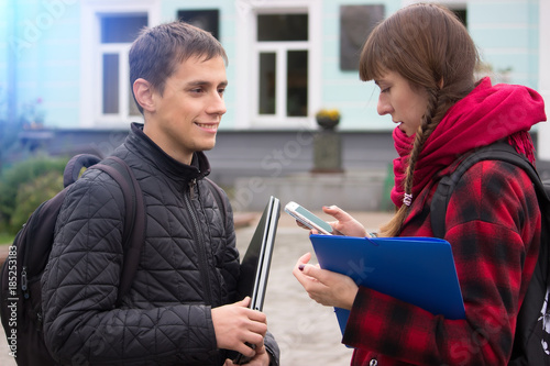 Tablou pe pânză Boy and girl exchanging phone numbers at street