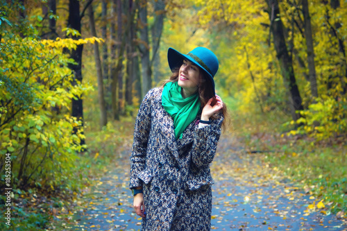 Pretty romantic girl in clothes walks in a park. The mood of autumn, leaf fall. Autumn fashion.