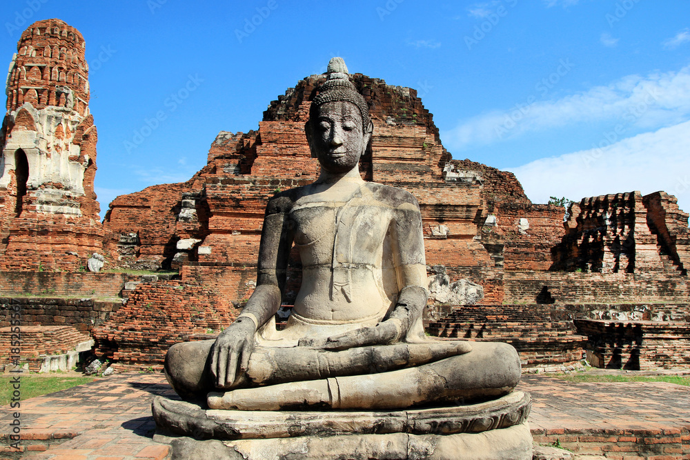 The ruins of ancient city with statue of Buddha. Ayutthaya Historical park. Ayutthaya, Thailand. The ruins of ancient city with statue of Buddha. Ayutthaya Historical park. Ayutthaya, Thailand.