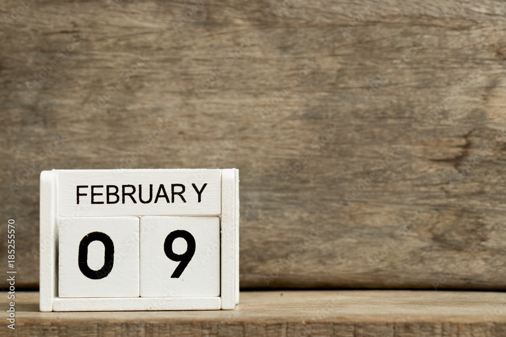 White block calendar present date 9 and month February on wood background White block calendar present date 9 and month February on wood background