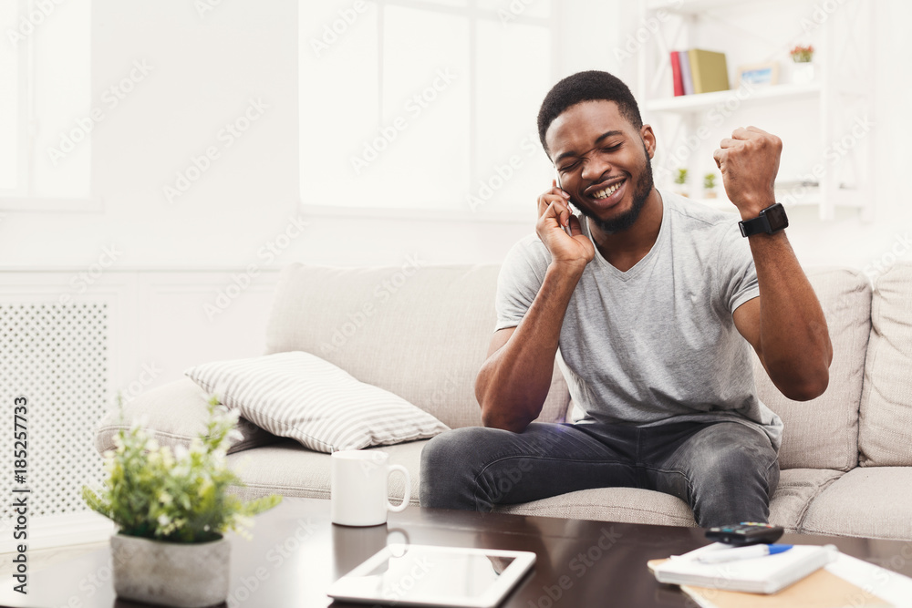 Happy young man talking on mobile at home Happy young man talking on mobile at home