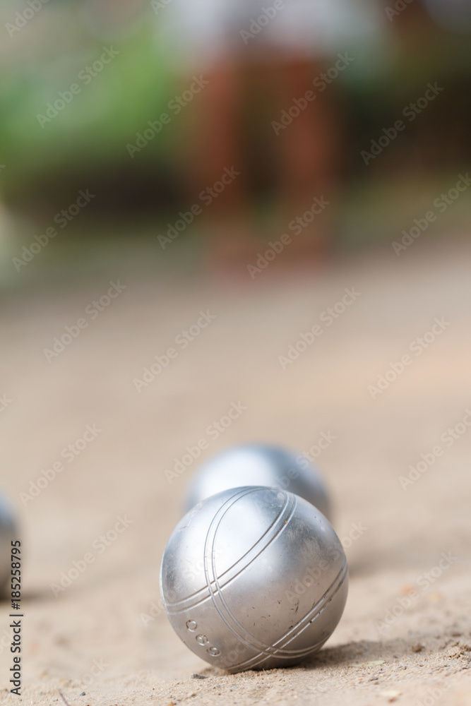 Boules or petanque ball in the match and player in back