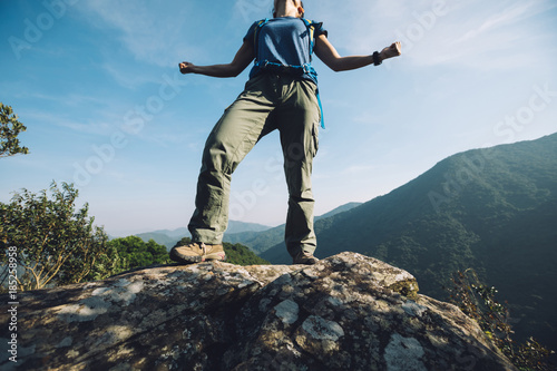 successful female hiker standing on cliff's edge