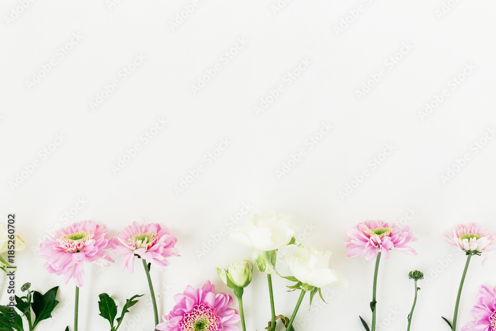 Valentine's composition with pink flowers and roses white background. Flat lay, top view.