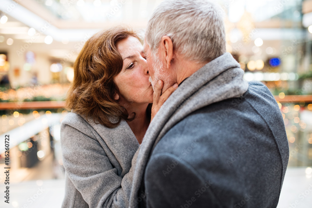 Senior couple doing Christmas shopping, kissing. Senior couple doing Christmas shopping, kissing.