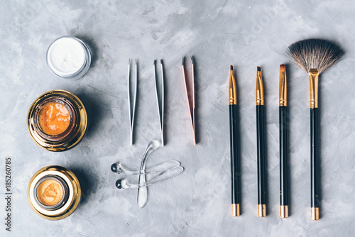 A set of tools, accessories and cosmetic for the care of the eyebrows on grey background. photo