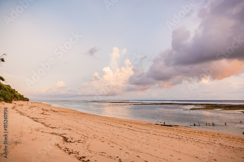 Tropical sandy beach and ocean at low tide in Bali at sunset