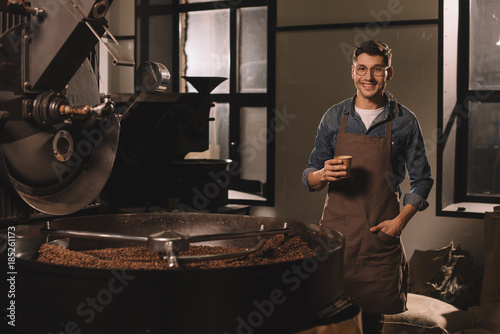 Quadro em tela smiling coffee roster with cup of coffee having break during work