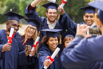 students or graduates with diplomas taking picture