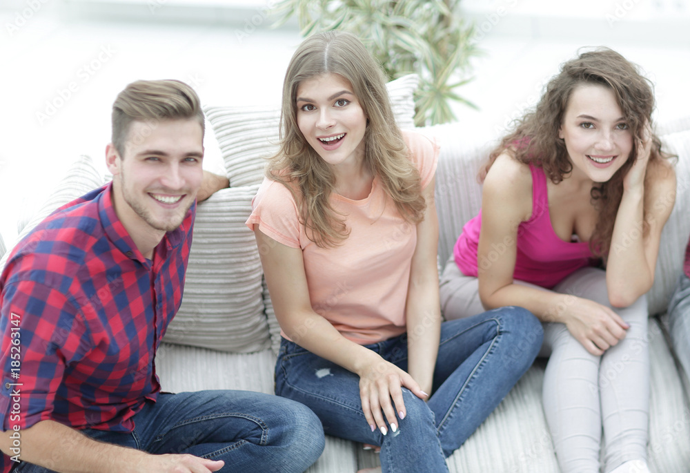group of cheerful friends watching videos, sitting on the couch group of cheerful friends watching videos, sitting on the couch