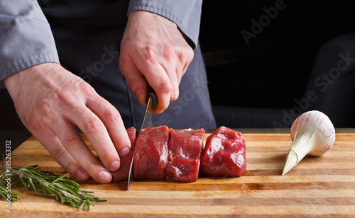 Fototapeta Naklejka Na Ścianę i Meble -  Chef cutting filet mignon on wooden board at restaurant kitchen
