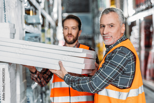 Obraz na płótnie two male workers holding styrofoam in shipping stock