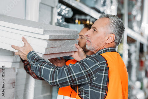 two male workers holding styrofoam in shipping stock photo