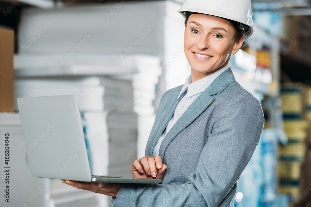 female inspector in helmet with laptop in warehouse female inspector in helmet with laptop in warehouse