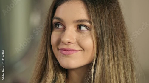 Face sensual woman with beautiful long hair touching skin on neck, biting sensual lips and sexy looking into camera close up