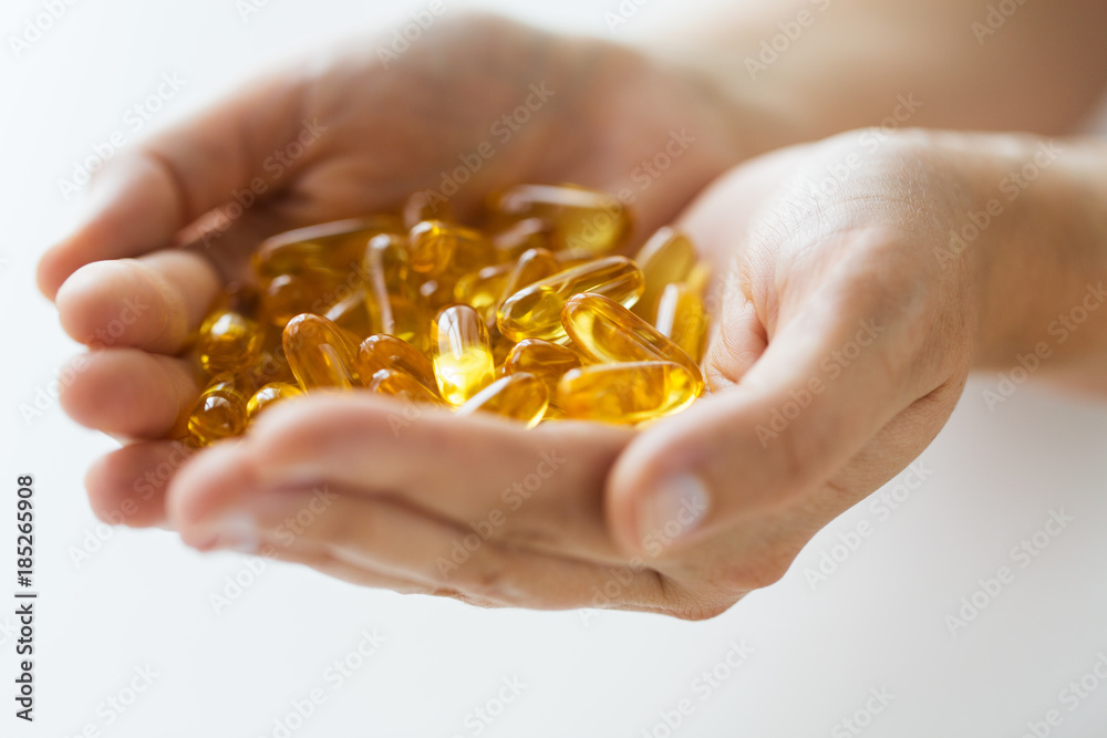 Fototapeta premium hands holding cod liver oil capsules
