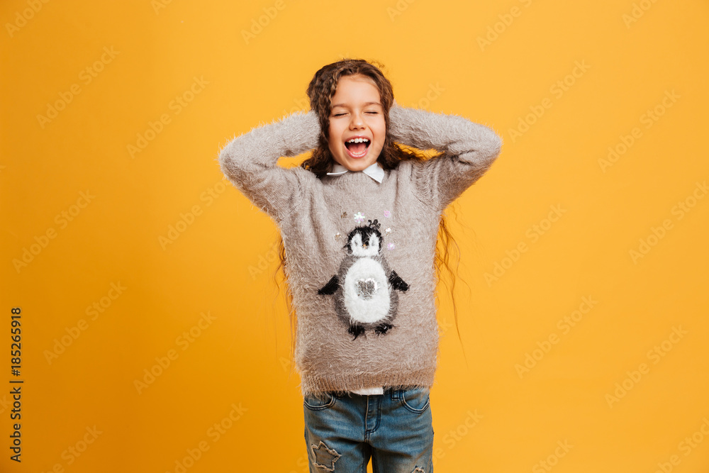 Fototapeta premium Excited screaming little girl child covering ears with hands.