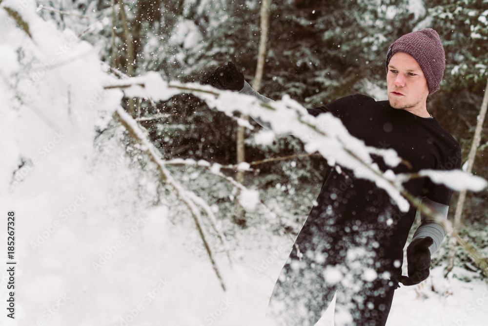 Young man shadow boxing in a forrest in Austria in the winter Young man shadow boxing in a forrest in Austria in the winter