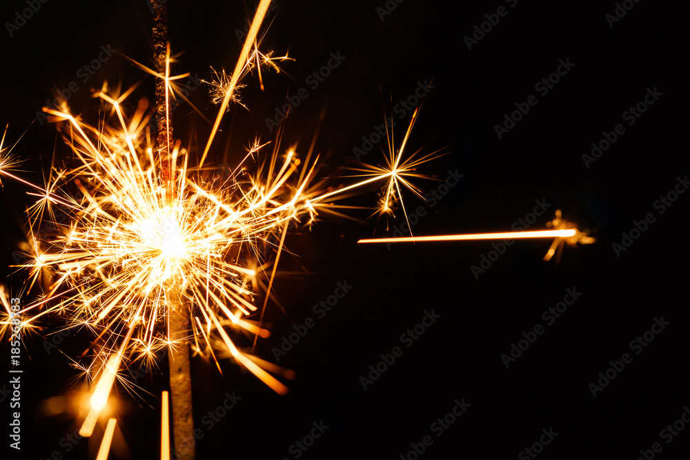 Burning sparkler isolated on black background blur