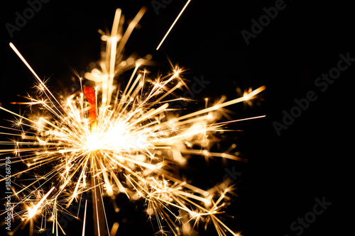 Burning sparkler isolated on black background blur