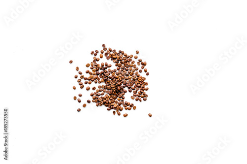 Scattered coffee beans on white table top view copyspace. Coffee background.