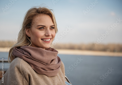 Portrait of young lady expressing harmony and pleasure while looking into distance. Copy space in right side