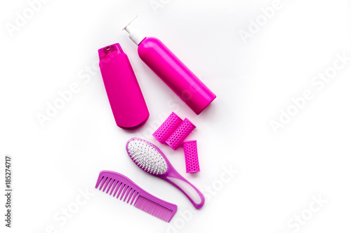 Women hair care set. Combs and shampoo on white background top view copyspace