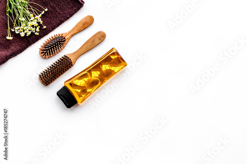 Fototapeta Naklejka Na Ścianę i Meble -  Women hair care set. Combs and shampoo on white background top view copyspace