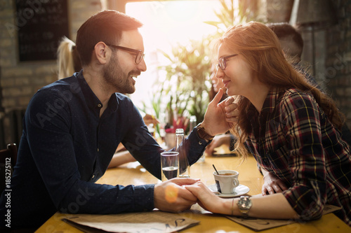 Handsome man flirting with cute woman in restaurant