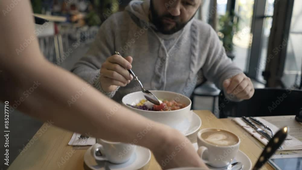 Moman gets cappuccino coffee during lunch from waiter in cafe
Moman gets cappuccino coffee during lunch from waiter in cafe