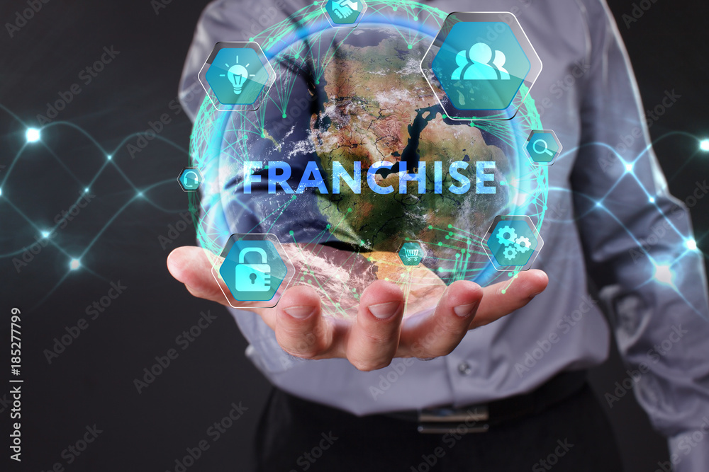 The concept of business, technology, the Internet and the network. A young entrepreneur working on a virtual screen of the future and sees the inscription: Franchise