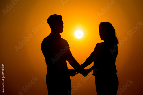 young couple silhouette at sunset