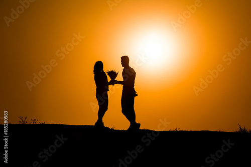 young couple silhouette at sunset