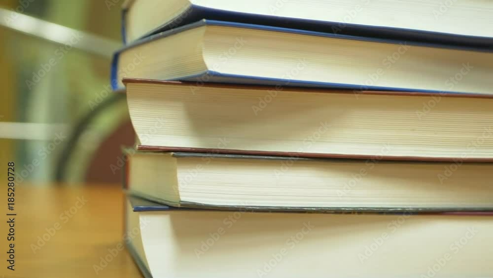 flying close up shot of stack of books on the table, blurred background flying close up shot of stack of books on the table, blurred background