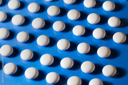 Pills. White medical pills on blue background.