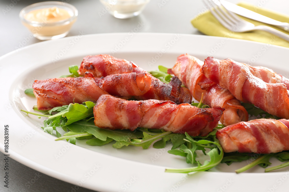 Plate with bacon wrapped chicken nuggets on table, closeup