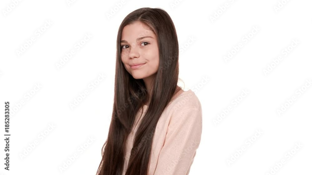 Close up portrait of charming lady with beautiful hair posing on camera smiling happily being flirty admiring herself over white background in studio. Concept of emotions Close up portrait of charming lady with beautiful hair posing on camera smiling happily being flirty admiring herself over white background in studio. Concept of emotions